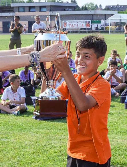 Giovane calciatore della Rhodense alza la coppa